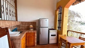Una cocina compacta con refrigerador, horno y armarios de madera.