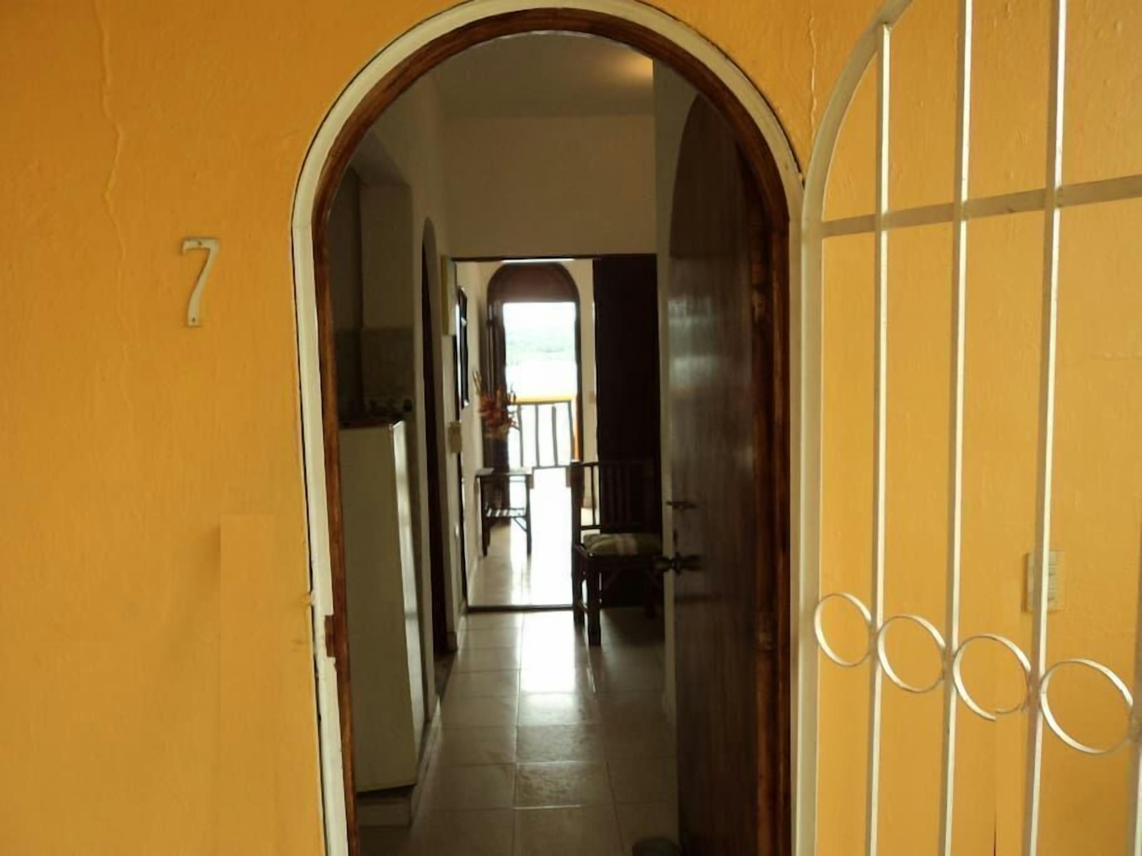 A hallway with a tiled floor leading to a room with a window.
