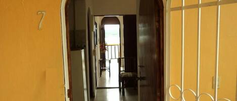 A hallway with a tiled floor leading to a room with a window.