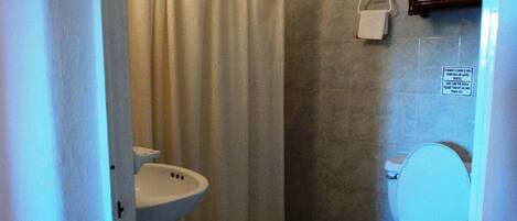 A small bathroom with a shower curtain, a sink, and a toilet.