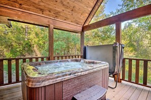 Un bain à remous sur une terrasse en bois, avec vue sur les arbres.