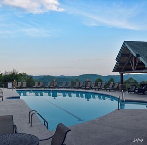 Relax by the pool surrounded by lounge chairs and a covered seating area, with a lifeguard stand for added safety.