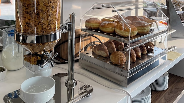 A breakfast buffet with a variety of food items, including cereal, fruits, pastries, and bread.