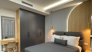 Un dormitorio moderno con una cama grande, un escritorio y un armario.