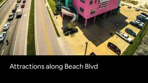 A pink building with a shark mouth design on the side, located along a beach with a view of the ocean. - Sunset Beach Hideaway (Gulfport)