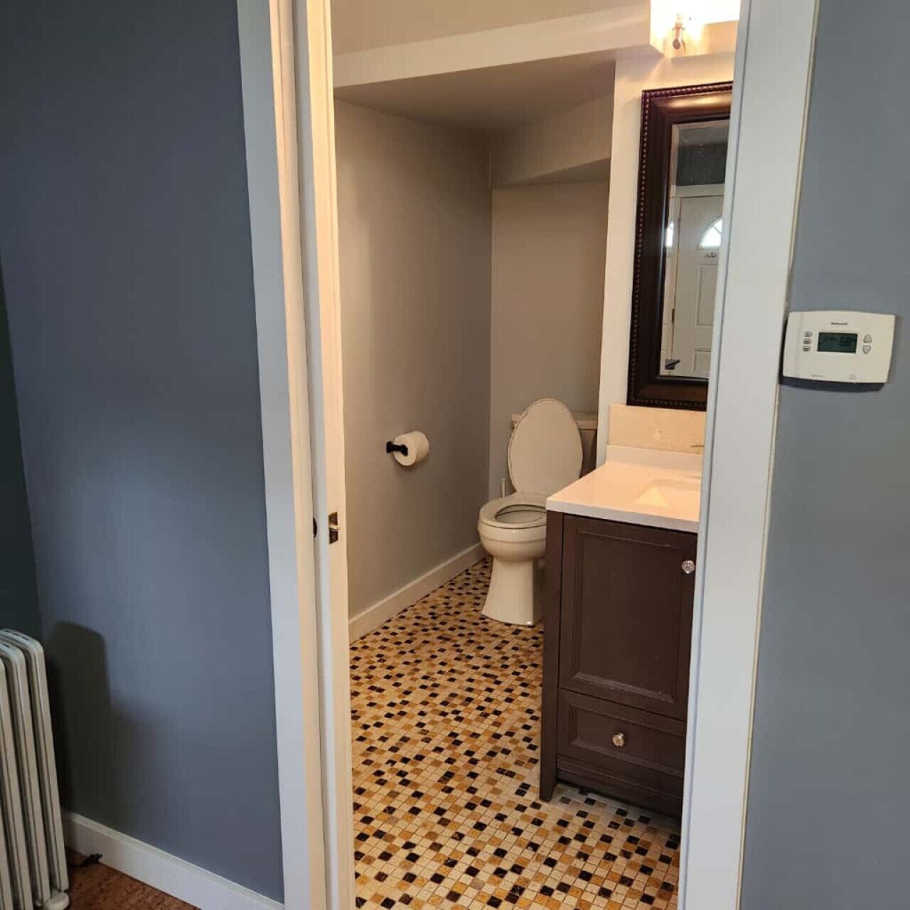 Une salle de bain avec des toilettes, un lavabo et un miroir.