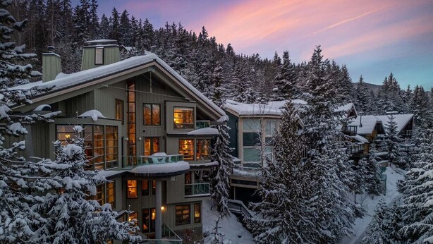 A multi-story lodge with a balcony, surrounded by snow-covered trees. - Panoramic views | Private hot tub | BBQ | Parking (Whistler)