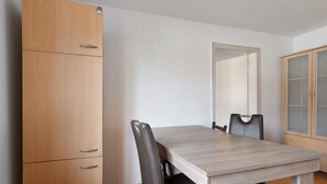 A dining area with a wooden table, two chairs, and a wardrobe. - Apartment 'Yellow  B' (Miltenberg)