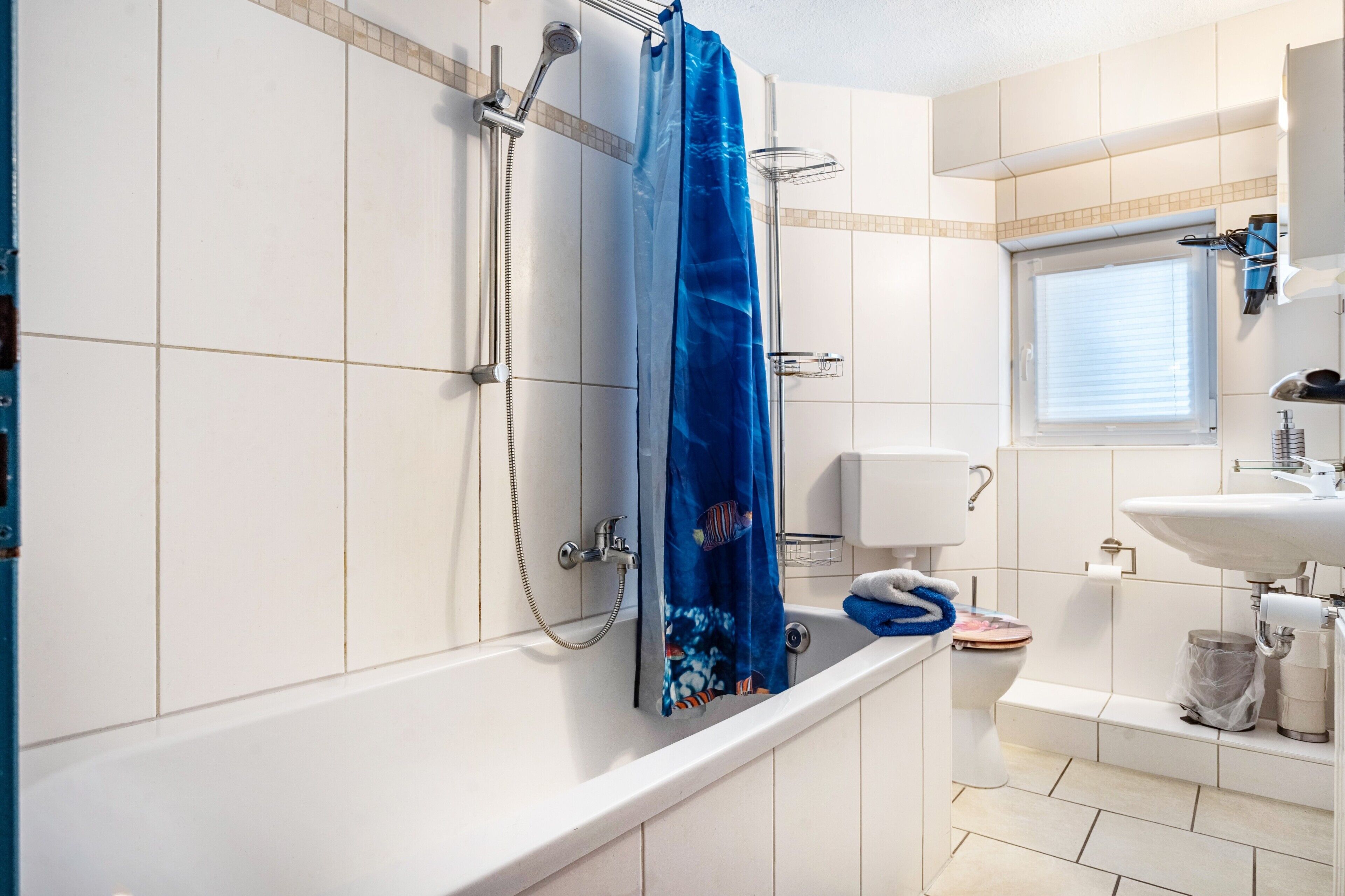 Un bagno dotato di vasca, doccia, WC e lavabo.