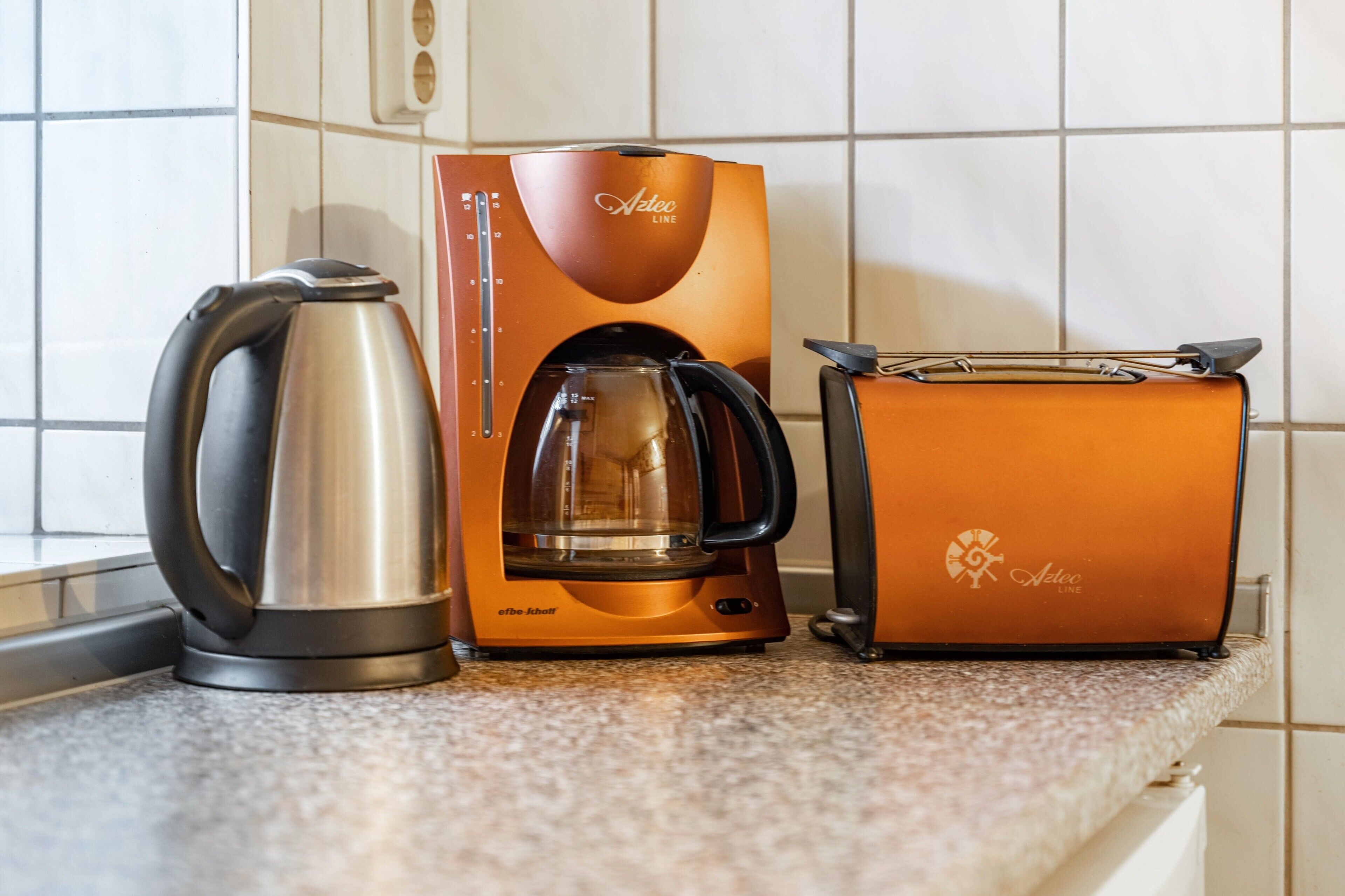 Eine Küche mit Kaffeemaschine, Toaster und Wasserkocher.