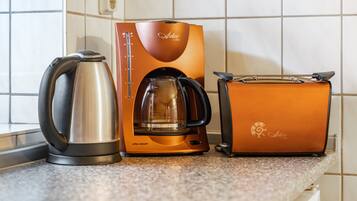 Eine Küche mit Kaffeemaschine, Toaster und Wasserkocher.