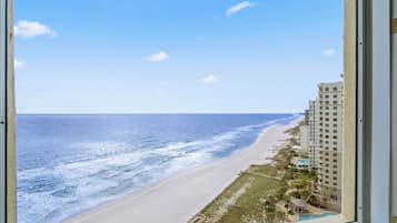 A view of a beach with a hotel in the background.