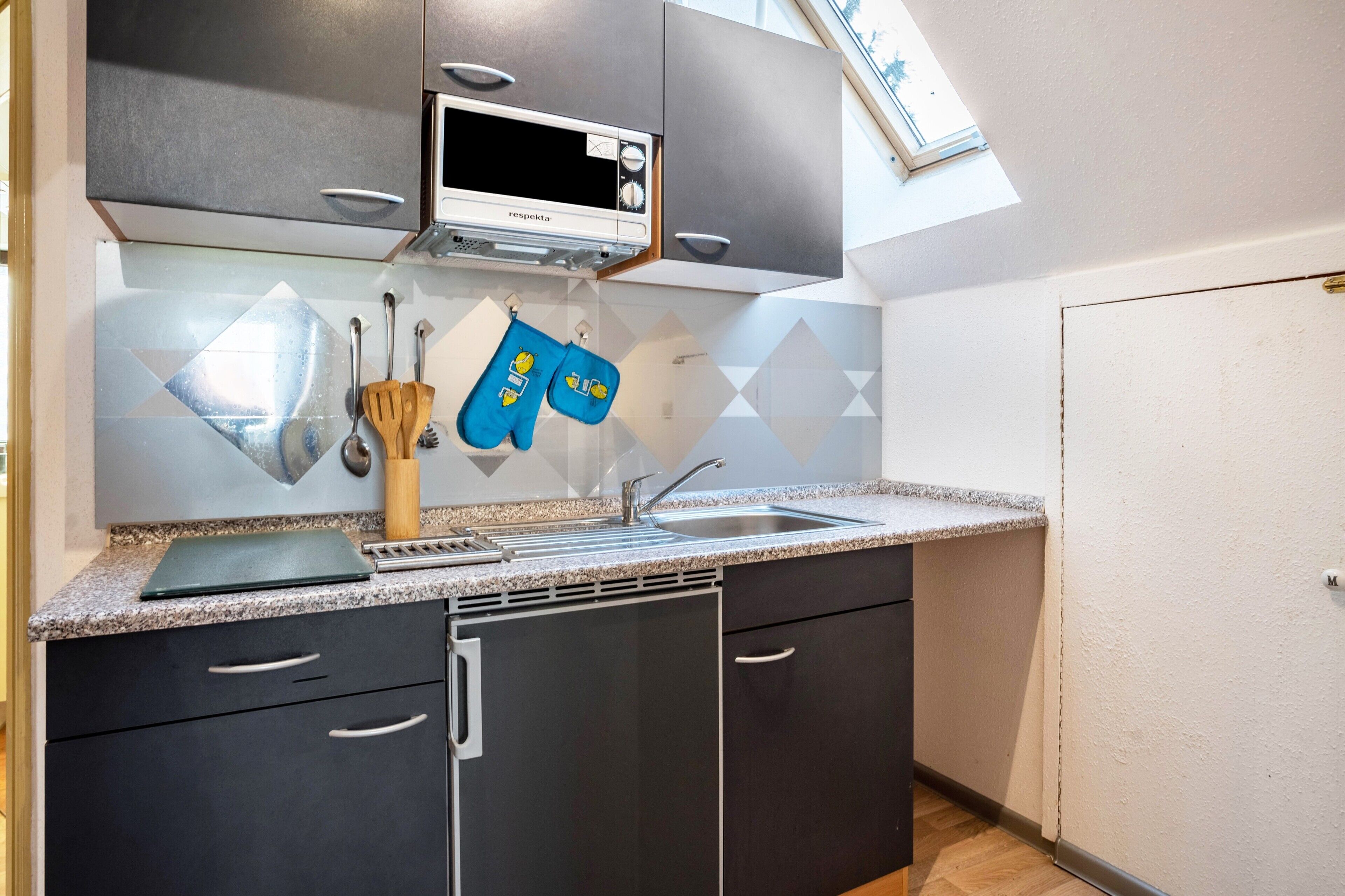 A kitchen with a microwave, sink, and cabinets.