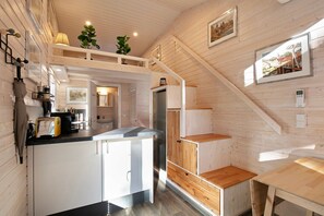 A compact kitchen with white cabinets, a wooden countertop, and a built-in stove. - Tiny House 'Tiny House Nr 3' with Private Terrace, Wi-Fi and Air Conditioning (Schwielowsee)