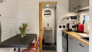 A compact kitchen with a wooden table, a sink, and a stove.