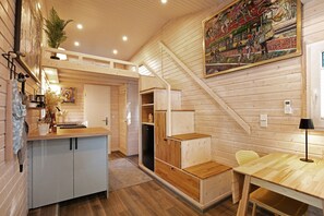 Un intérieur en bois comprenant une cuisine, un coin repas et un escalier.
