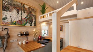 Une cuisine avec des meubles de rangement en bois, un évier et une fenêtre.