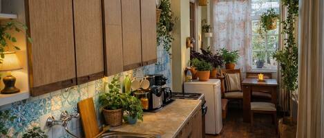 A kitchen with wooden cabinets, a sink, and a dining area with a table and chairs.