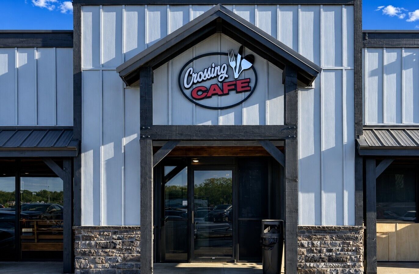 Un bâtiment avec une enseigne indiquant « Crossing Cafe » et une base en pierre.