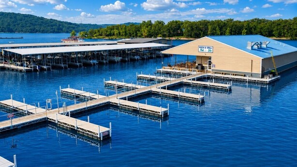 A waterfront property with a pizza and grill restaurant, multiple docks, and a large building with a blue roof. - Pleasure Point at Kimberling Crossing (Kimberling City)