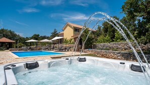 A hot tub with water jets, a swimming pool, outdoor furniture, and a house in the background. - Villa Nina (Istria - Buje) (Buje)