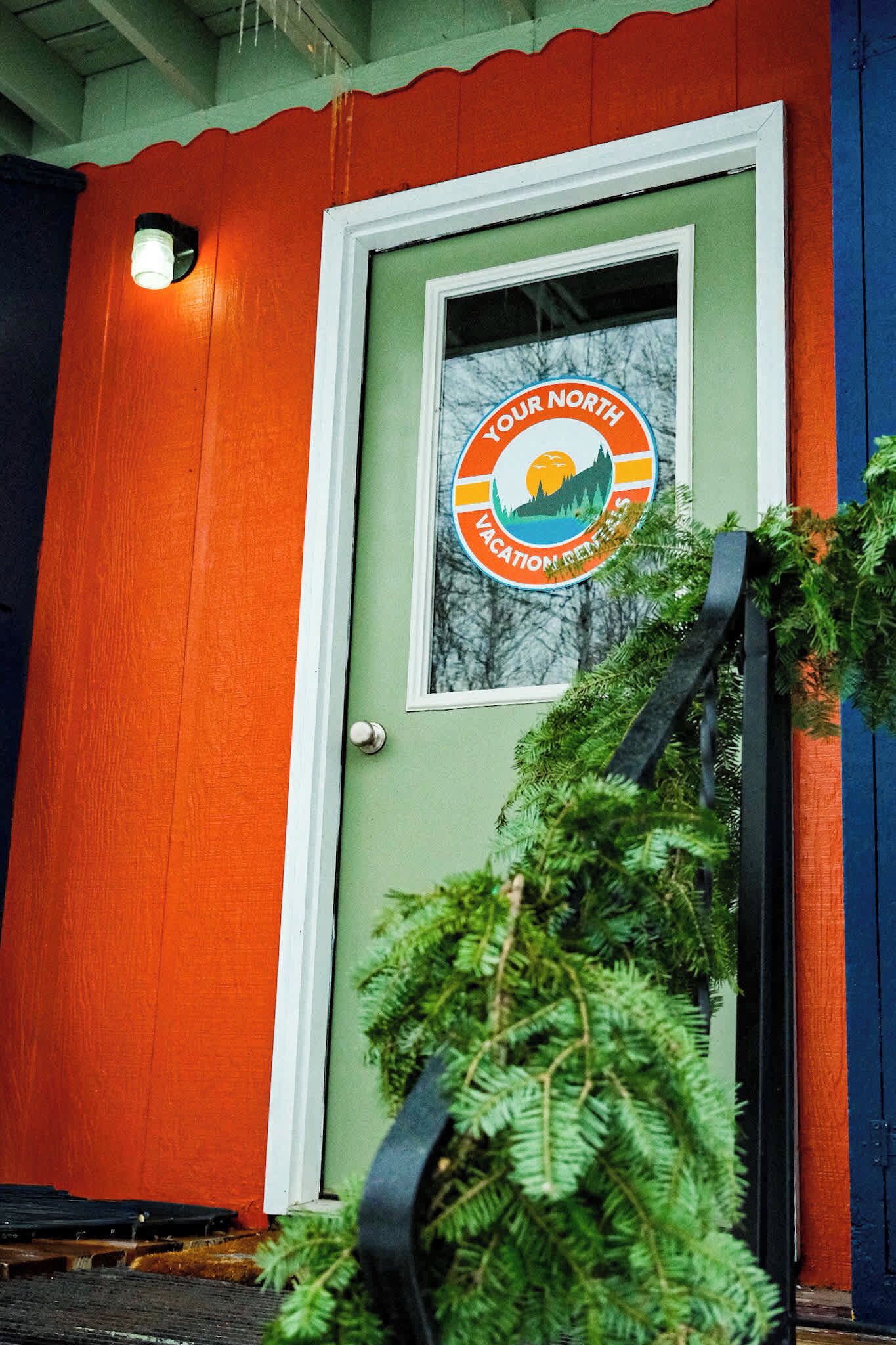 Une porte ornée d’un logo circulaire sur lequel on peut lire : « Your North Vacation Inn ».