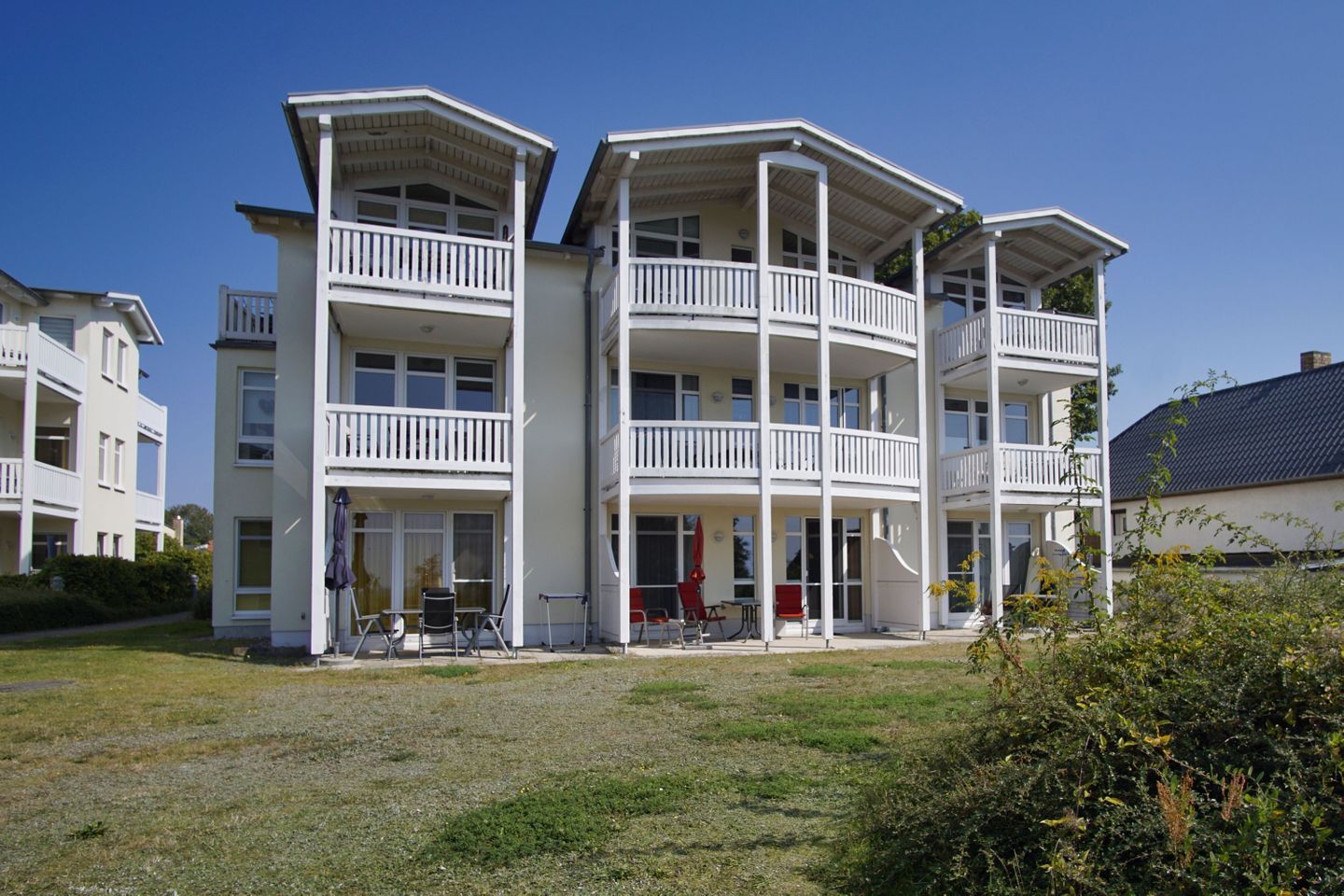 A multi-story building with balconies and a covered outdoor area.