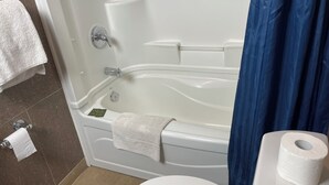 A bathroom with a bathtub, toilet, and a towel rack. - WAYFARE MOTEL (Guelph)