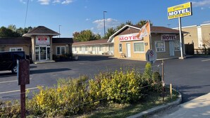 A motel with a signboard, a welcome sign, and a no parking sign. - WAYFARE MOTEL (Guelph)