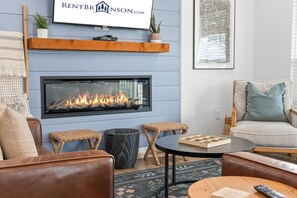A modern living room with a fireplace, comfortable seating, and a mounted television. - Breathtaking Lakeview Retreat with Private Hot Tub, Dog-Friendly, Cmty Pools & $400 Free Tickets (Branson)