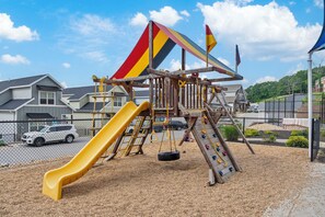 A playground with a slide, climbing structures, and a tire swing. - Breathtaking Lakeview Retreat with Private Hot Tub, Dog-Friendly, Cmty Pools & $400 Free Tickets (Branson)