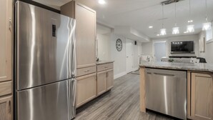 A modern kitchen with stainless steel appliances, wooden cabinets, and pendant lighting. - Fully Reno'd 2 Bedroom, 2 Bath Legal Basement Suite. Heart of the Southside (Lethbridge)
