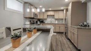 A modern kitchen with wooden cabinets, a granite countertop, and stainless steel appliances. - Fully Reno'd 2 Bedroom, 2 Bath Legal Basement Suite. Heart of the Southside (Lethbridge)