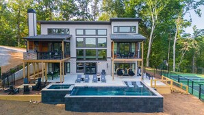 A modern two-story house with a large swimming pool, outdoor seating, and a tennis court. - Retreat at Clear Creek ~ Outdoor Pool & Pickleball/Basketball Court! (Ellijay)