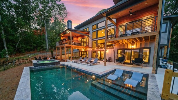 A modern two-story house with a swimming pool, outdoor seating, and a large deck area. - Retreat at Clear Creek ~ Outdoor Pool & Pickleball/Basketball Court! (Ellijay)