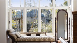 A room with a large window, a bench, and a mirror.