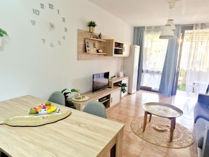Relax in a spacious living area with a dining table, flat-screen TV, and comfortable seating.