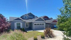 A modern two-story house with a garage, a driveway, and a well-maintained lawn.