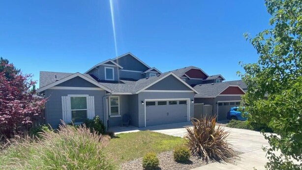 A modern two-story house with a garage, a driveway, and a well-maintained lawn. - Nightly or short term rental in Medford. (Medford)