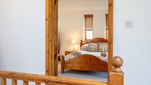 Un dormitorio con una cama de madera, una mesita de noche, una lámpara y una ventana con persianas.