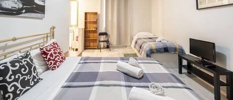 Tabla de planchar con plancha y ropa de cama