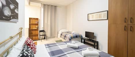 Tabla de planchar con plancha y ropa de cama
