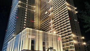 Un hotel de gran altura con varios pisos, amplias ventanas y fachada bien iluminada.