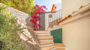 A staircase leading to a door, surrounded by plants and a white wall. - One haven with stunning views (Alcabideche)