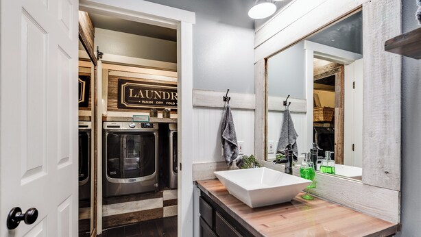 A modern bathroom with a large mirror, a white sink, and a wooden vanity. - Welcoming Guest Suite in Snohomish (Snohomish)