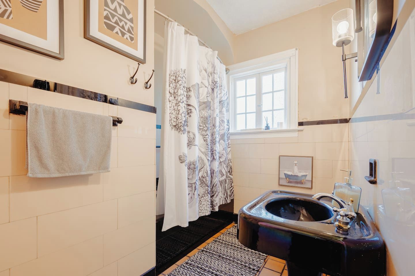 Un baño con bañera, toallero, ventana y cortina de ducha.