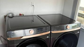 Zona de bugaderia amb dues rentadores superposades.