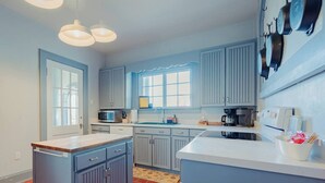 Una cocina con isla central, electrodomésticos integrados y ventana que proporciona luz natural.