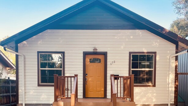 A single-story house with a front porch, a brown front door, and two windows on either side. - Cozy 3-bedroom house in charming Casper with AC, WiFi. Centrally located!  (Casper)