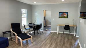 A modern living room with a dining table, chairs, a blue sofa, and a wooden coffee table. - Cozy 3-bedroom house in charming Casper with AC, WiFi. Centrally located!  (Casper)